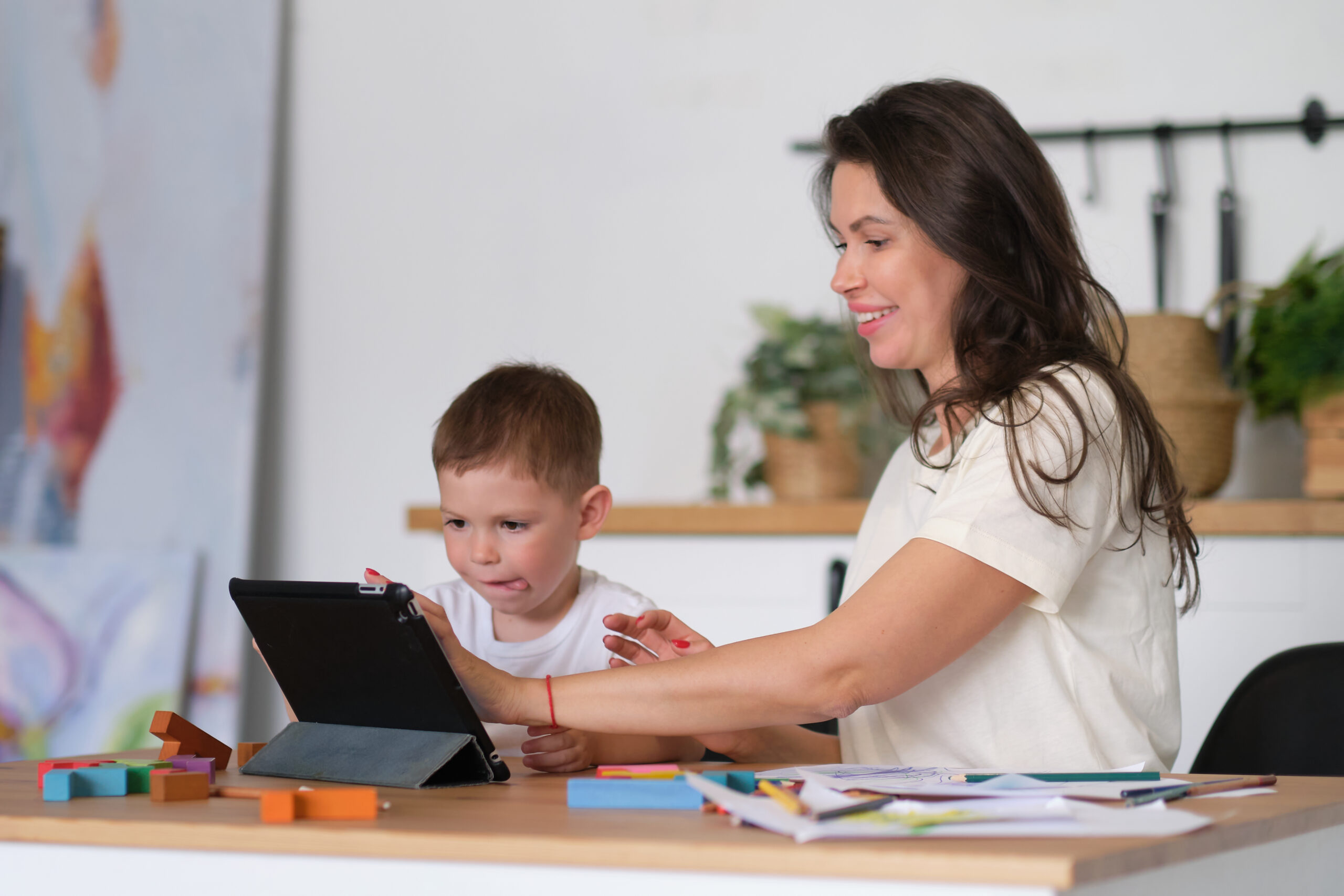 Mother helping child in taking online lessons